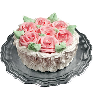 white frosted cake with pink roses