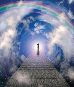 Man walking on brick path towards sky with rainbow