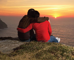 couple on hilltop watching sunset