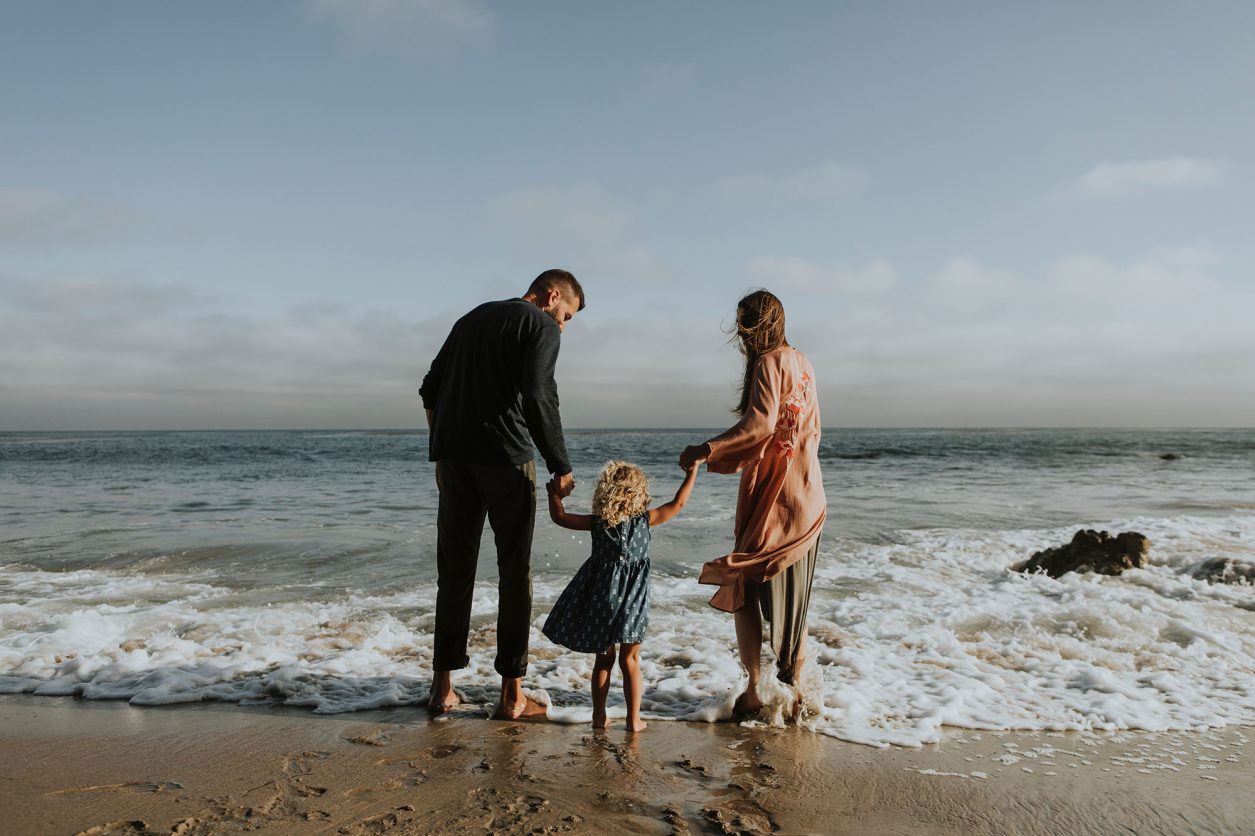 parents with child at the ocean