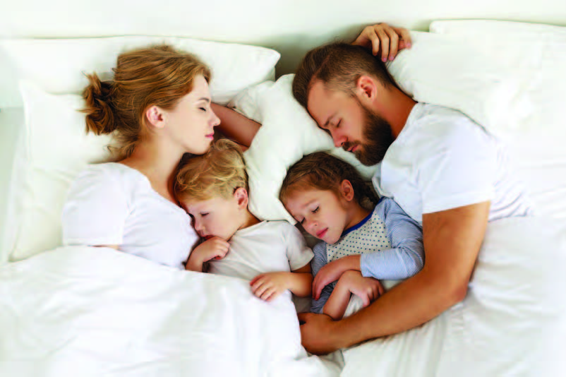 Sleeping family in bed