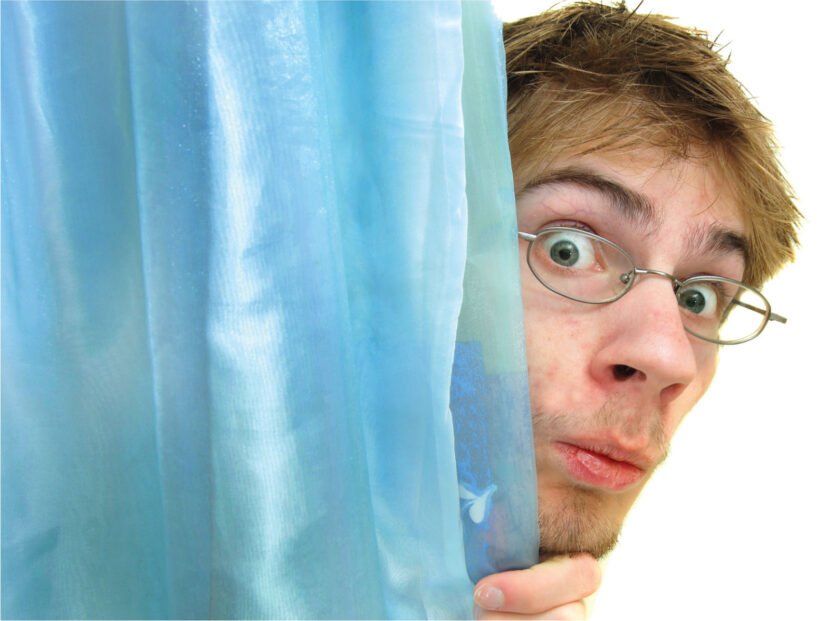 man peeking behind a curtain